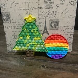 A Christmas tree pop it and a rainbow circle pop it